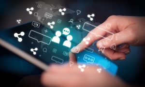 Close-up of a hand using tablet, social media concept