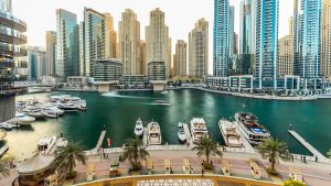 Dubai marina with modern buildings and traditional boat timelapse